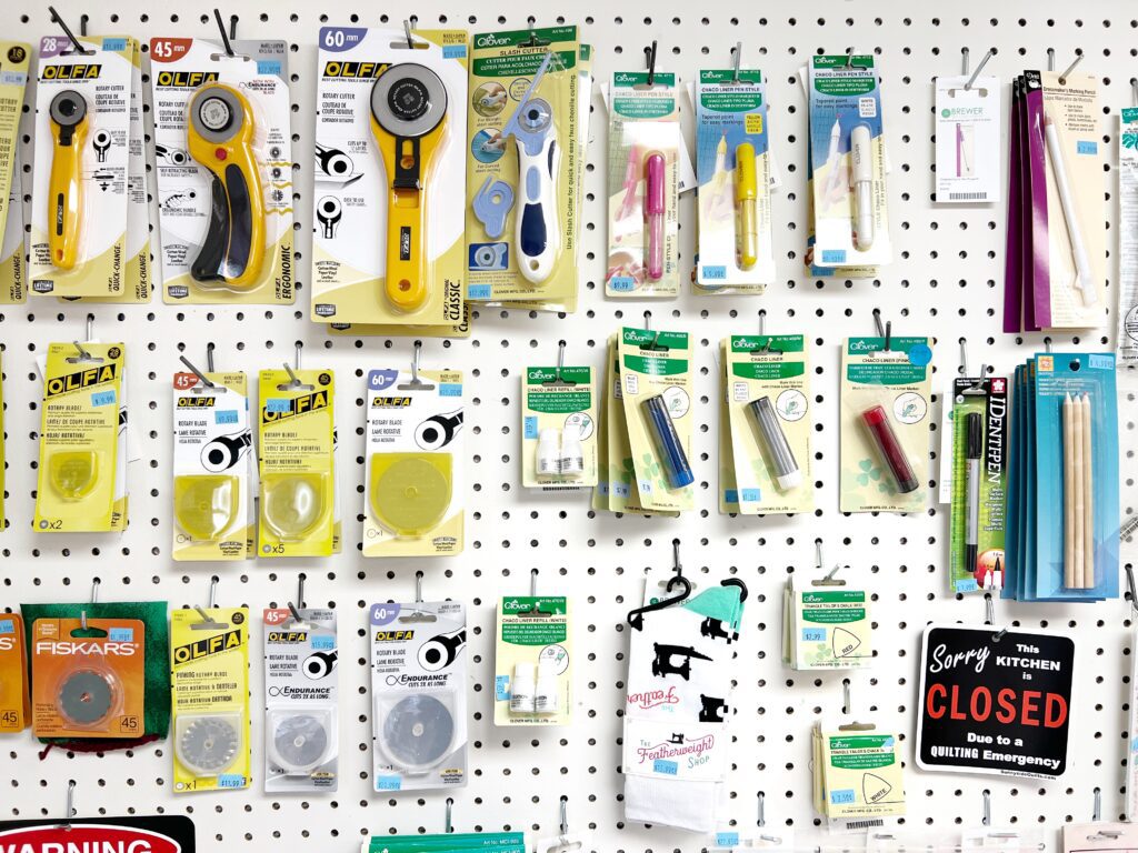 Notion wall at the sewing machine shop. Image shows sewing supplies on the wall.